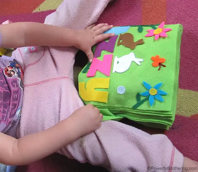 a little girl very happy with her felt book