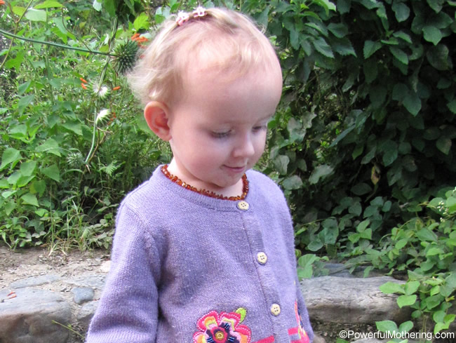 little girl wearing amber teething necklace